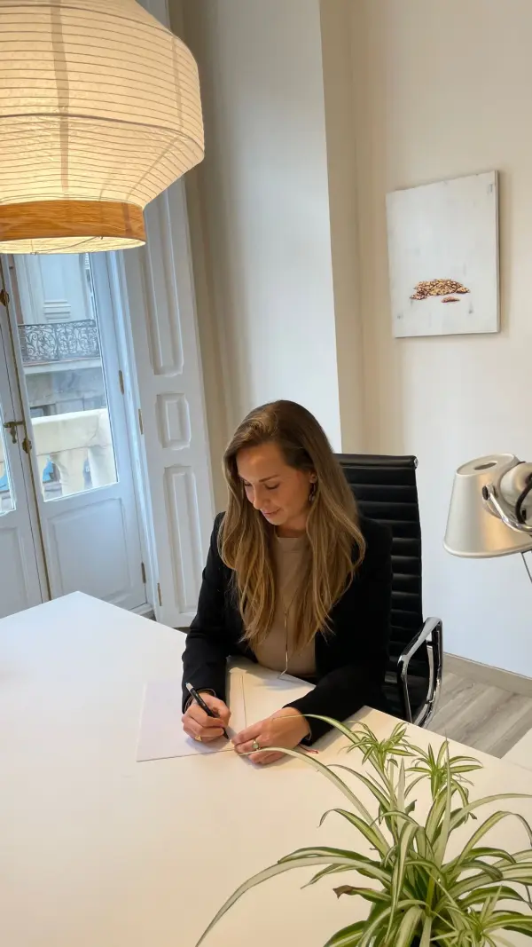 Andrea Martín escribiendo en su escritorio, junto al balcón de la consulta