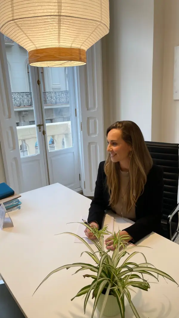Andrea Martín sonriendo en su escritorio, junto al balcón de la consulta