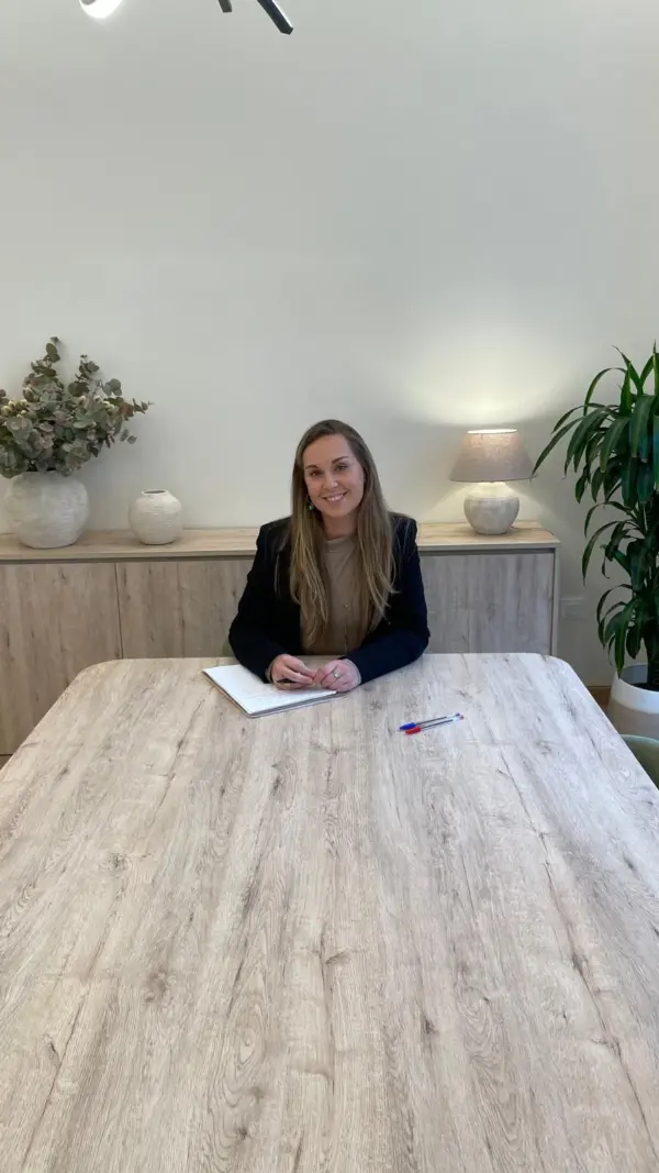 Andrea Martín sentada a la mesa de madera de la sala de consulta