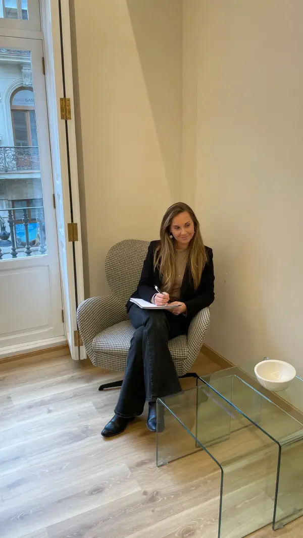 Andrea Martín tomando notas en un sillón de su consulta