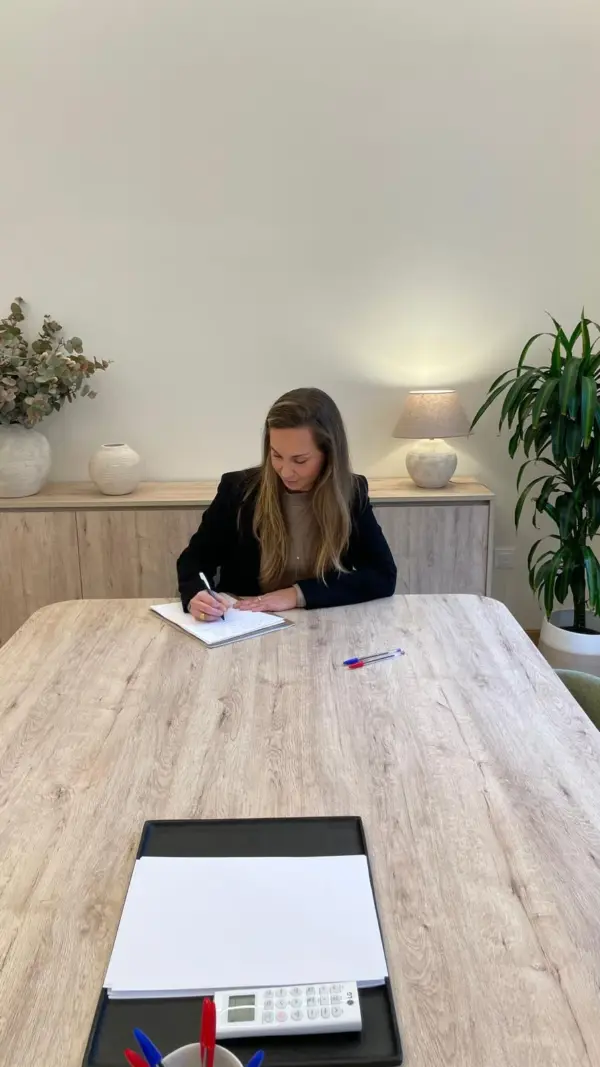 Andrea Martín tomando notas en la mesa de trabajo de la consulta